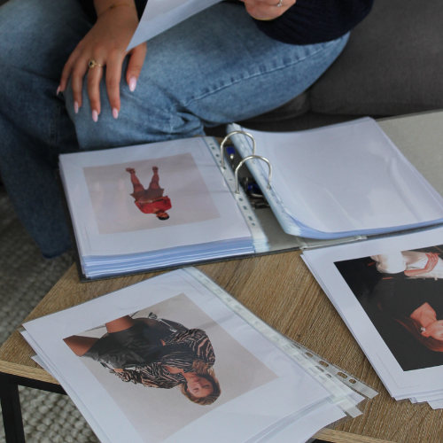 Exprimer son style idéal : un moment fort d’un EVJF coaching en image à Nice Main d’une femme présentant des photos de styles vestimentaires inspirants lors d’un atelier de coaching en image EVJF à Nice.